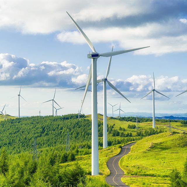 series of wind turbines in a field on a hill