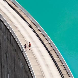 people walking on edge of hydrogen dam