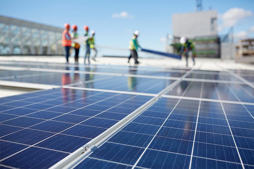 six people installing solar panels